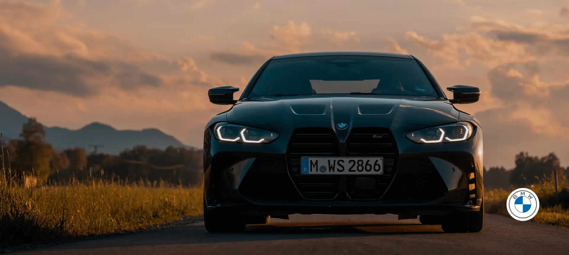 Black car on country road at sunset