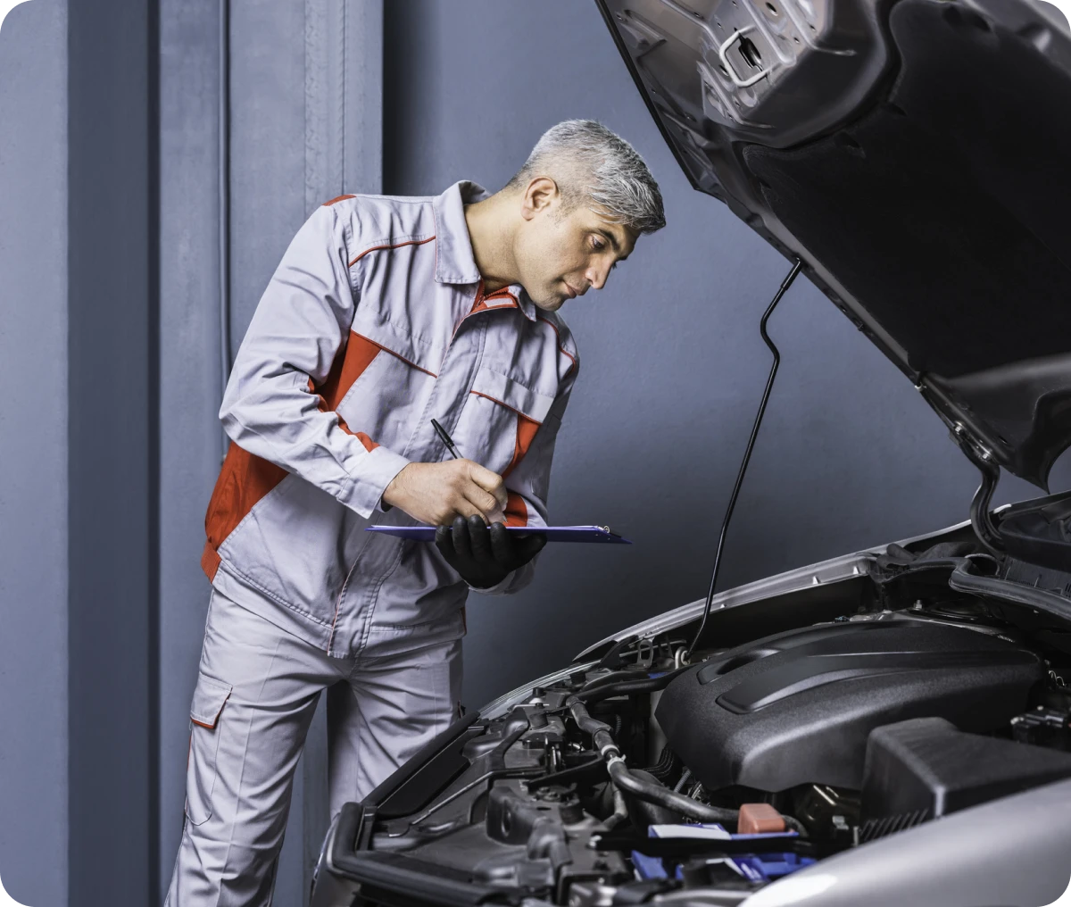 Auto technician checking engine